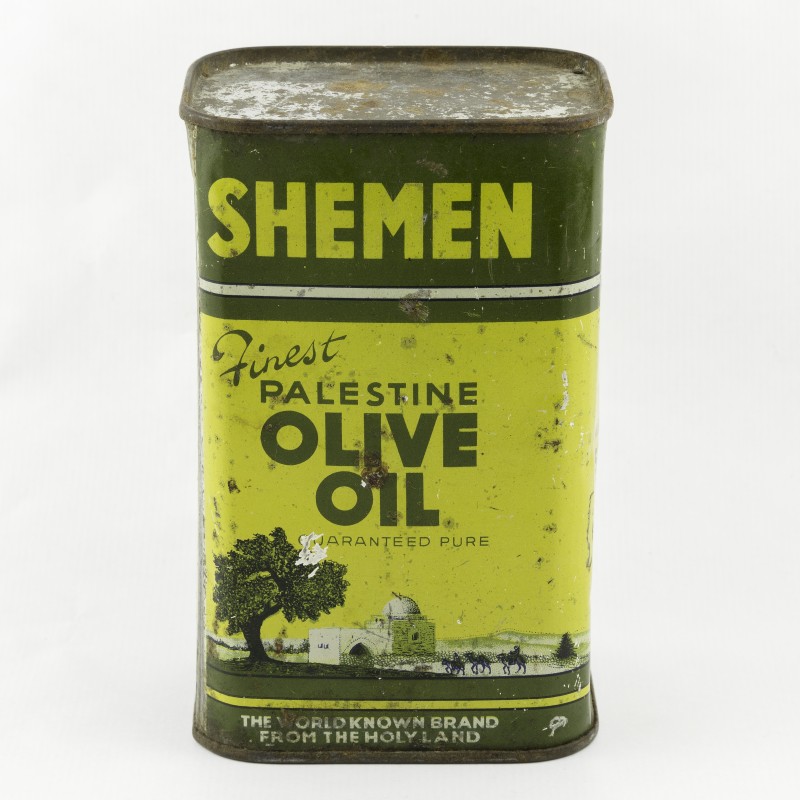 Metallkanne mit Aufschrift 'SHEMEN Finest Palestine Olive Oil' und Illustration mit Baum, Tor und Kamelkarawane
