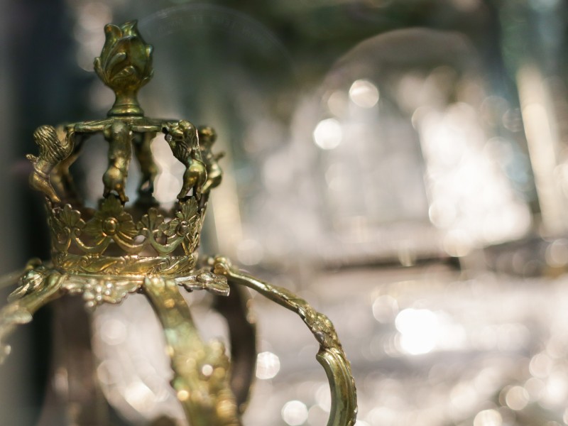 Goldene Krone Nahaufnahme: Nahaufnahme einer goldenen Krone mit detaillierten Verzierungen, unscharfer Hintergrund mit Lichtern