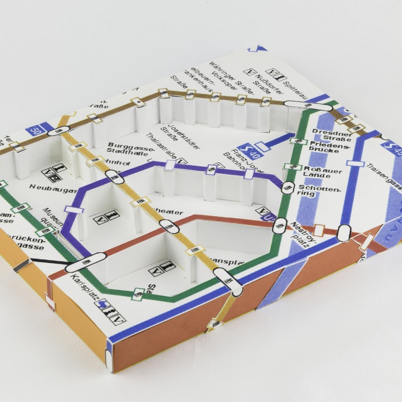 Miniaturmodell eines U-Bahn- und Straßenbahnnetzes mit farbigen Linien, Stationen und Verbindungsknoten