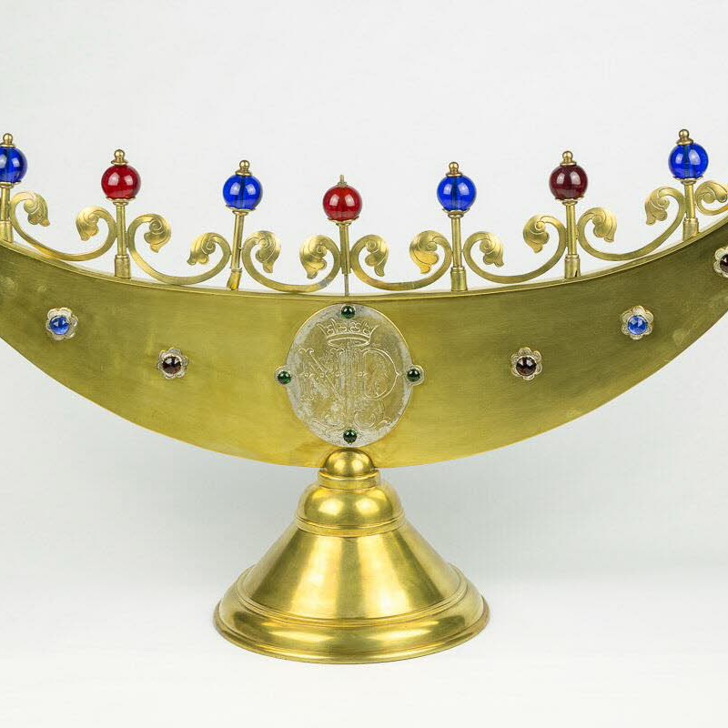 Goldener Chanukka-Leuchter in horizontal gekrümmter Form mit sieben roten und blauen Kugeln an goldenen Stäben und Sockel