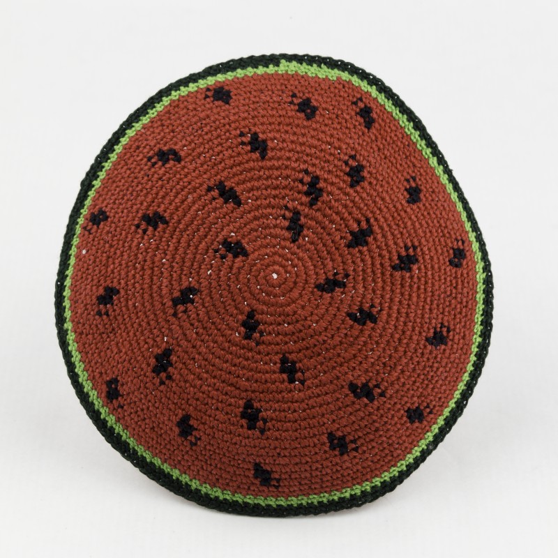Rundes gehäkeltes Kippah mit einem Muster, das wie eine Wassermelone mit rotem Zentrum, schwarzen Punkten und grünem Rand aussieht