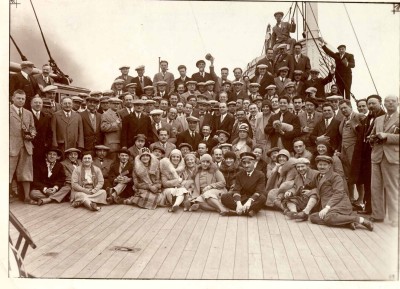 : Musiker der New Yorker Philharmoniker mit ihren Ehefrauen sitzend in der ersten Reihe und den Crewmitgliedern, 1930. Steffy Goldner ist die einzige stehende Frau (Mitte rechts, neben dem Mann mit Hund).