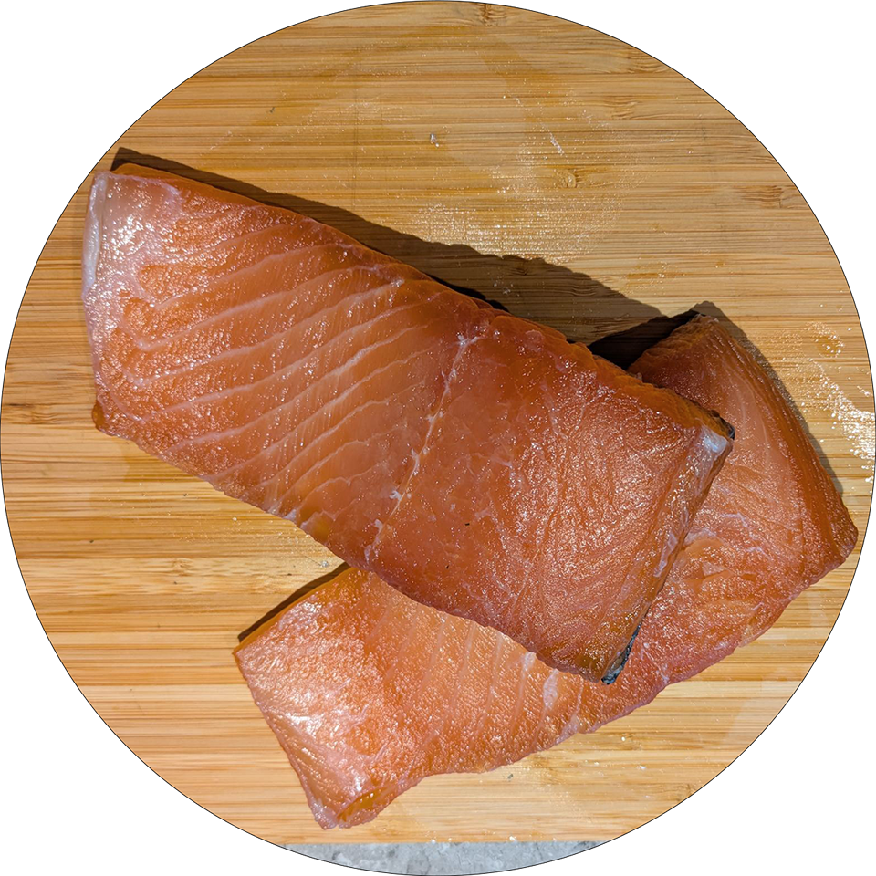 Two pieces of gravad salmon on a wooden board